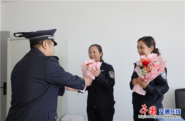 图二：伊宁县公安局阿乌利亚乡派出所教导员王旭东为党建女警送上鲜花