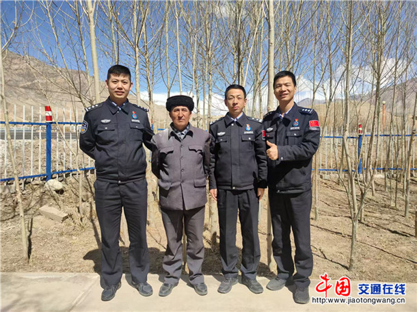图为何超（右二）在基层走访时与驻地老乡合影。何伟摄